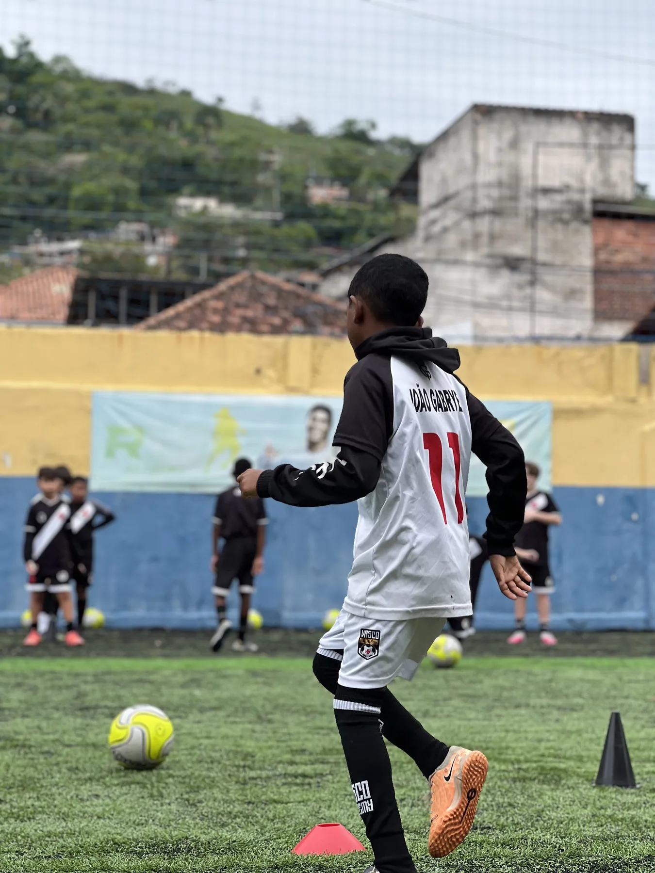 Aluno da Vasco Academy com a camisa 11 conduzindo a bola no treino